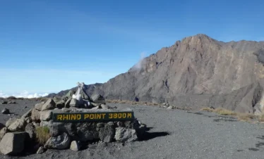 Sign marking Rhino Point at 3800 meters elevation with rocky terrain in the background.
