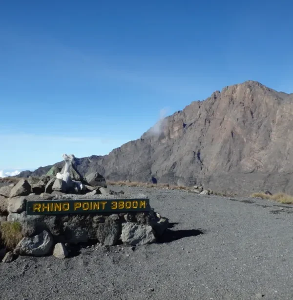 Sign marking Rhino Point at 3800 meters elevation with rocky terrain in the background.