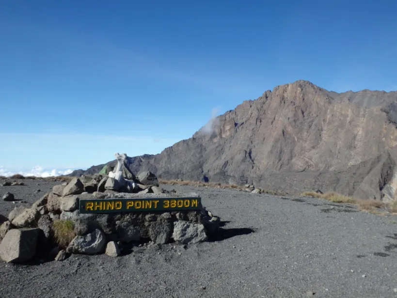 Sign marking Rhino Point at 3800 meters elevation with rocky terrain in the background.