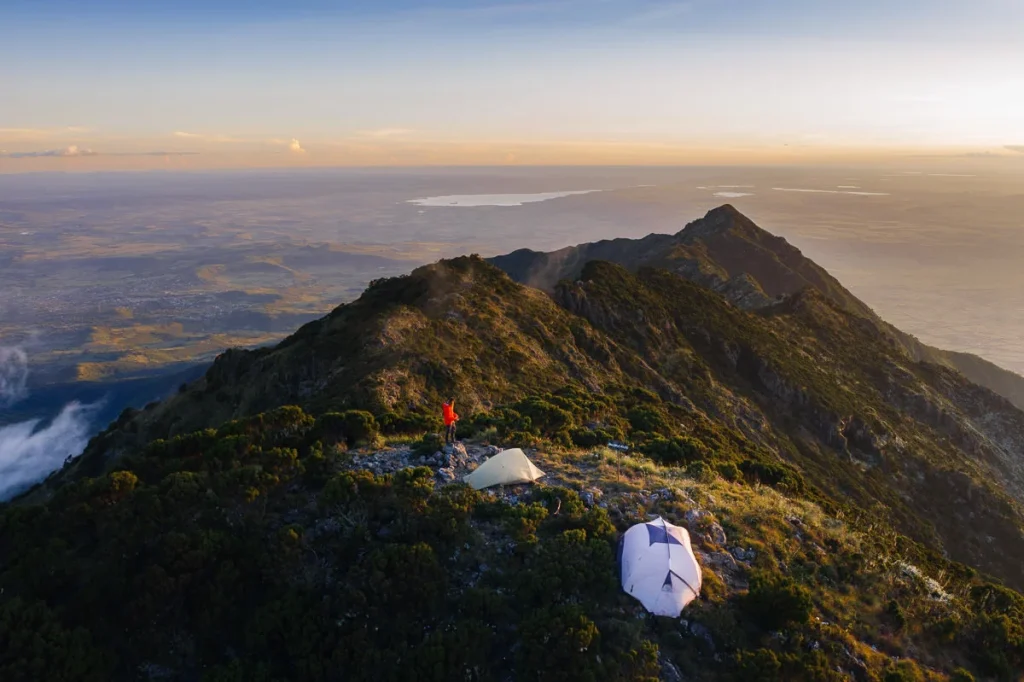 Campsite on Mount Hanang with tents set up on a ridge overlooking the landscape in Tanzania.