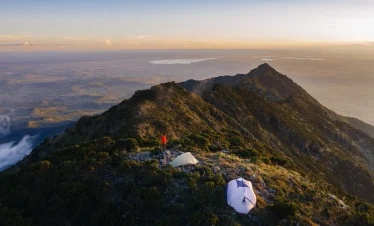 Campsite on Mount Hanang with tents set up on a ridge overlooking the landscape in Tanzania.