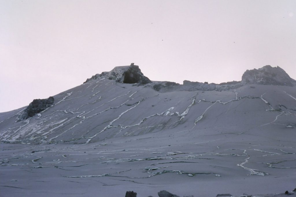 Ol Doinyo Lengai, an active volcano in Tanzania, with a gray landscape and rocky formations.