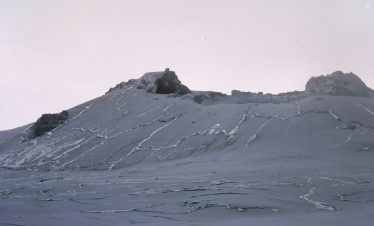 Ol Doinyo Lengai, an active volcano in Tanzania, with a gray landscape and rocky formations.