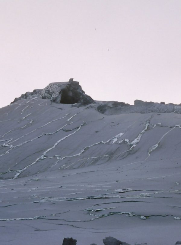 Ol Doinyo Lengai, an active volcano in Tanzania, with a gray landscape and rocky formations.